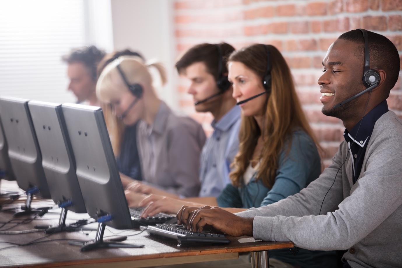 smiling call center employees sitting in line